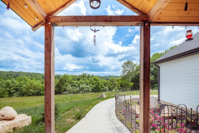 exterior space featuring a wooded view and fence