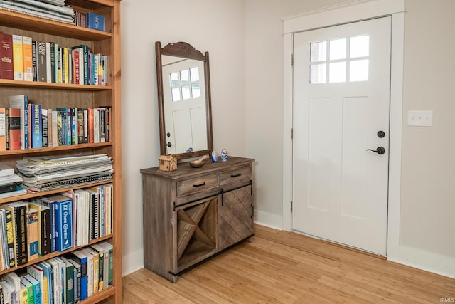 foyer entrance with light wood-type flooring and baseboards