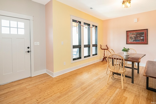 dining room featuring visible vents, baseboards, and light wood finished floors