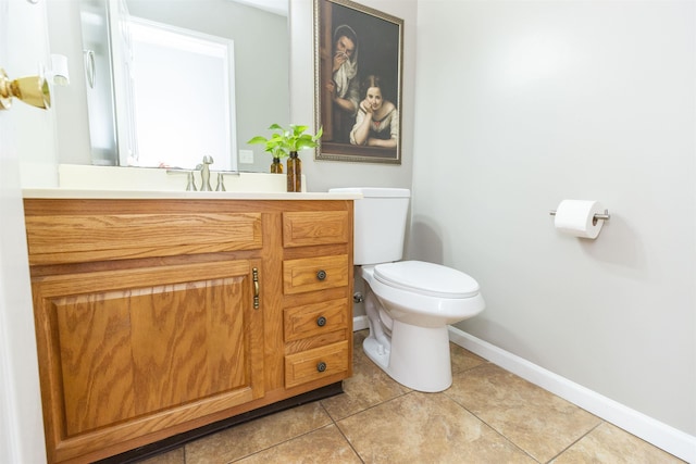 half bathroom featuring baseboards, toilet, vanity, and tile patterned flooring