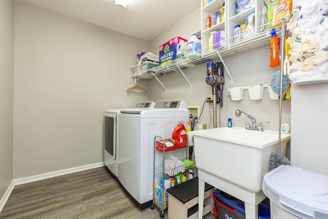 laundry area featuring washer and dryer, a textured ceiling, wood finished floors, baseboards, and laundry area