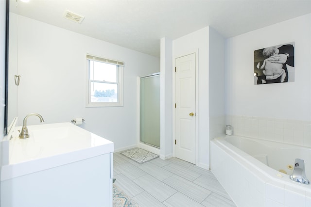 bathroom with visible vents, a shower stall, baseboards, a whirlpool tub, and vanity