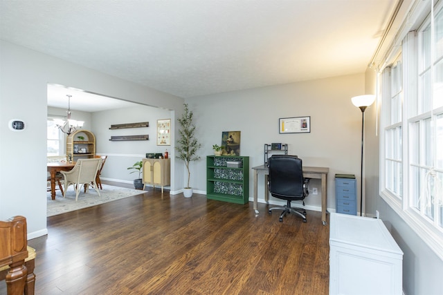 office area featuring baseboards, a notable chandelier, and dark wood finished floors