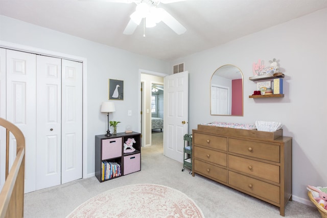 bedroom featuring visible vents, light carpet, a ceiling fan, a closet, and baseboards