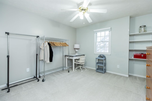 carpeted office featuring baseboards and a ceiling fan