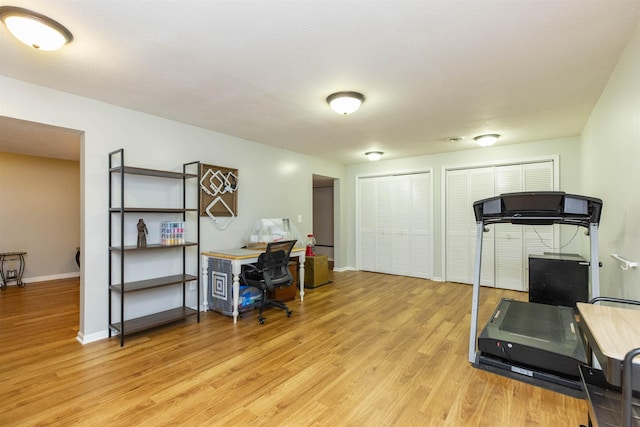 home office with baseboards and light wood finished floors