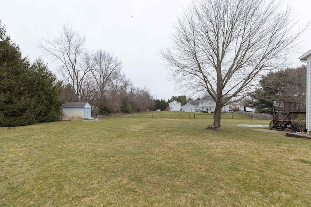 view of yard with an outbuilding, a storage shed, and fence