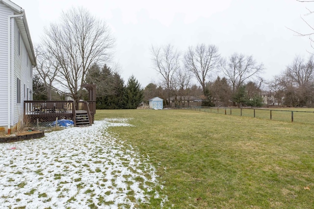 view of yard with an outdoor structure, fence, a shed, and a wooden deck