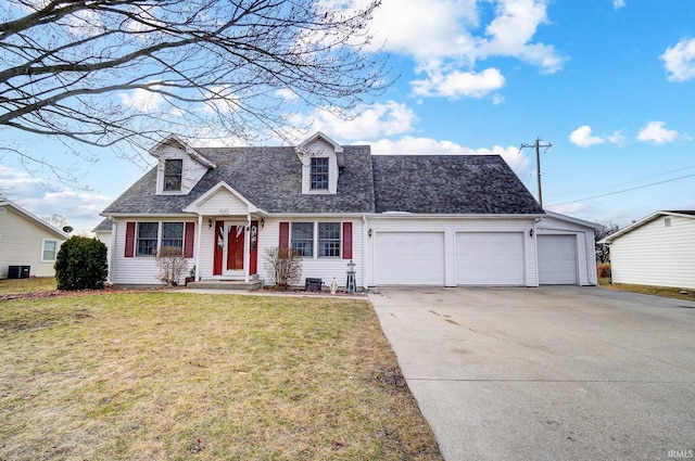 new england style home featuring concrete driveway, a front yard, a garage, and a shingled roof