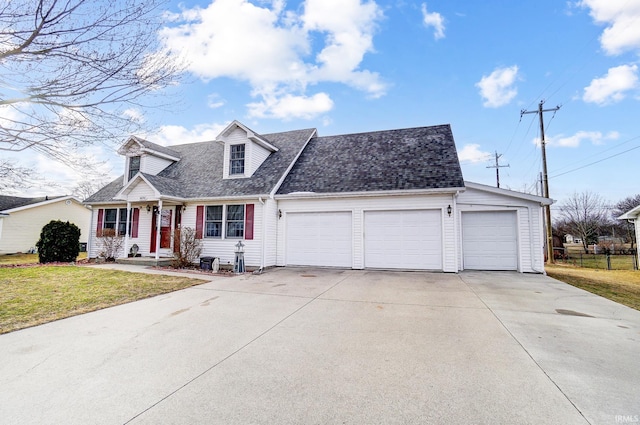 cape cod-style house with a garage, driveway, a shingled roof, and a front yard