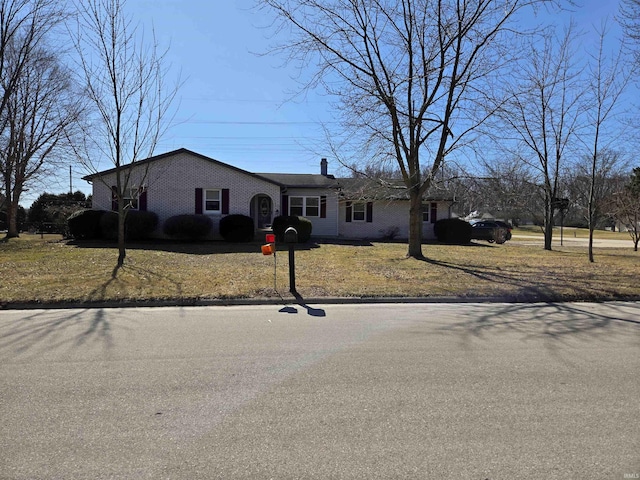 view of front of house with brick siding and a chimney