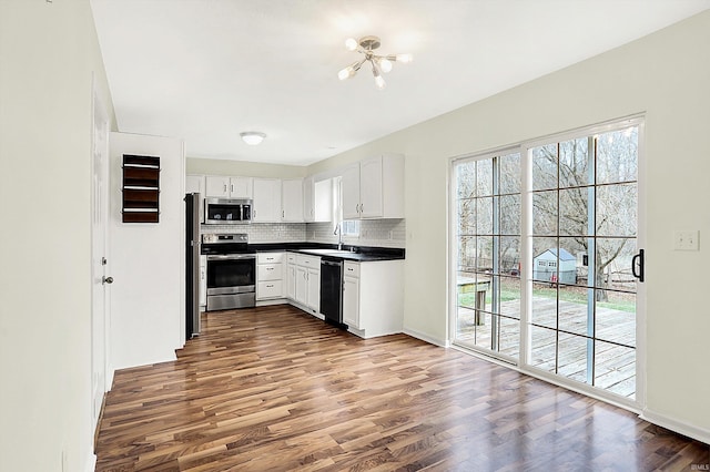 904 S Deer Run, Ellettsville, IN 47429 - kitchen featuring dark countertops, dark wood finished floors, decorative backsplash, stainless steel appliances, and a sink