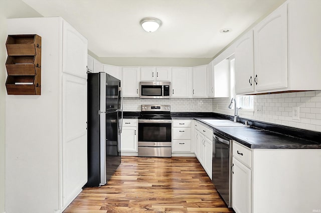 904 S Deer Run, Ellettsville, IN 47429 - kitchen featuring a sink, dark countertops, appliances with stainless steel finishes, and white cabinetry