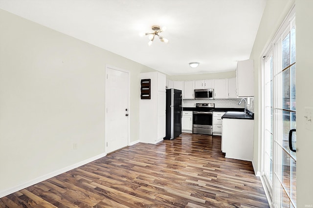 904 S Deer Run, Ellettsville, IN 47429 - kitchen featuring dark countertops, decorative backsplash, dark wood-style flooring, appliances with stainless steel finishes, and a sink