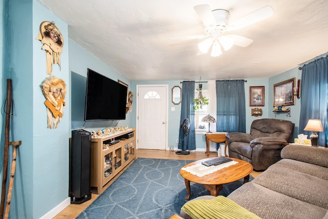 living room with wood finished floors, baseboards, and ceiling fan