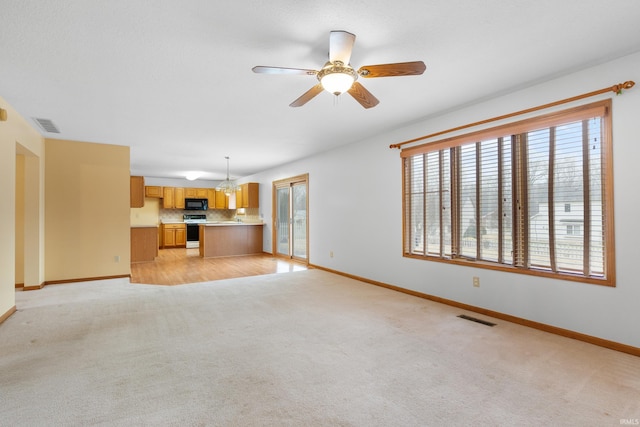 unfurnished living room with visible vents, baseboards, and light colored carpet