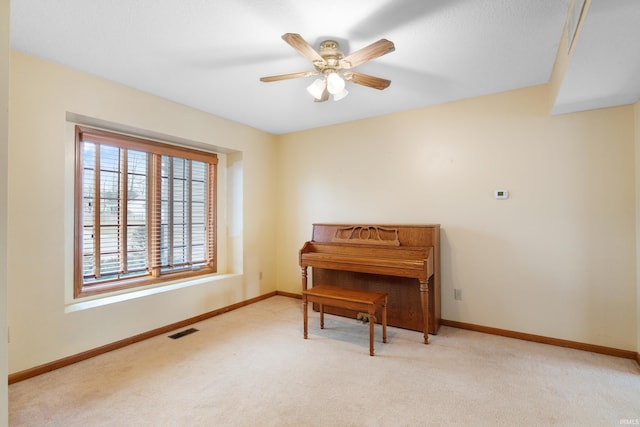 sitting room with a ceiling fan, carpet, visible vents, and baseboards