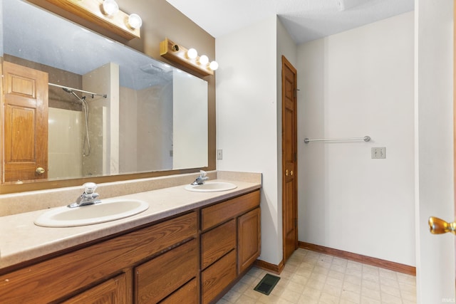 bathroom featuring a sink, visible vents, double vanity, and tile patterned floors