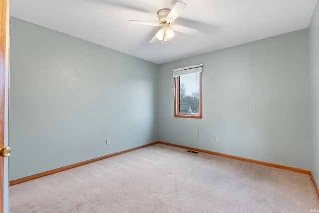 carpeted empty room featuring a textured ceiling, baseboards, and ceiling fan