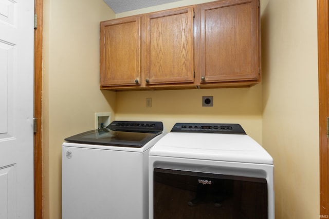 washroom featuring cabinet space and independent washer and dryer