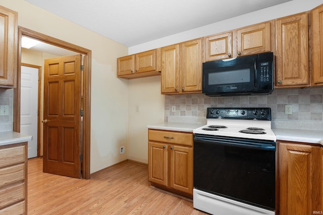 kitchen with light countertops, electric stove, black microwave, light wood-type flooring, and backsplash