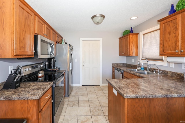 kitchen with brown cabinets, a sink, dark countertops, stainless steel appliances, and baseboards