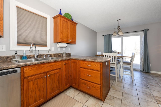 kitchen featuring dishwasher, brown cabinets, a peninsula, light tile patterned flooring, and a sink