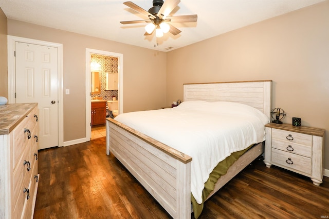 bedroom with dark wood-style floors, connected bathroom, baseboards, and ceiling fan