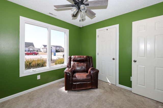 sitting room featuring baseboards, visible vents, ceiling fan, a textured ceiling, and carpet flooring