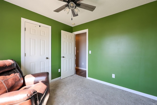 living area with ceiling fan, baseboards, and carpet