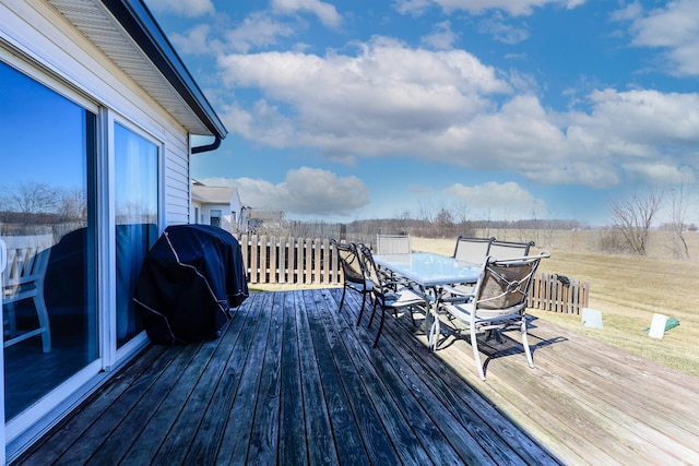 deck featuring area for grilling, a lawn, and outdoor dining area