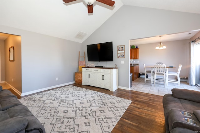 living room with visible vents, baseboards, wood finished floors, and ceiling fan with notable chandelier