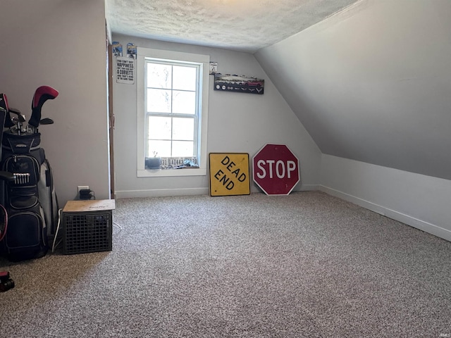 playroom with lofted ceiling, carpet, baseboards, and a textured ceiling