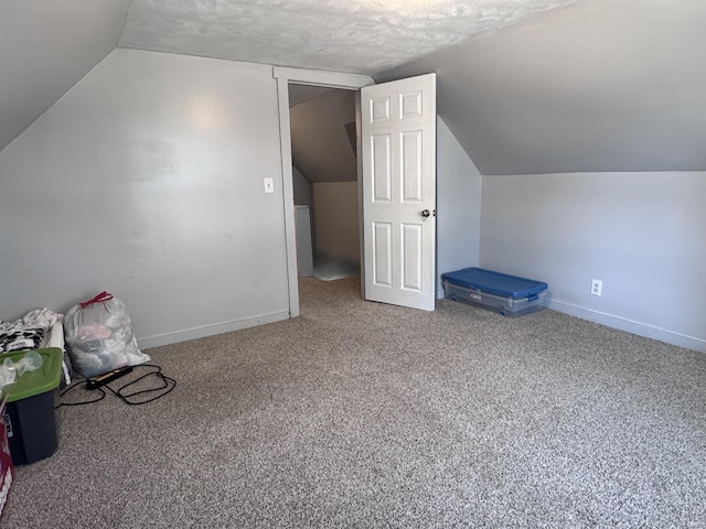 additional living space featuring baseboards, carpet, and vaulted ceiling