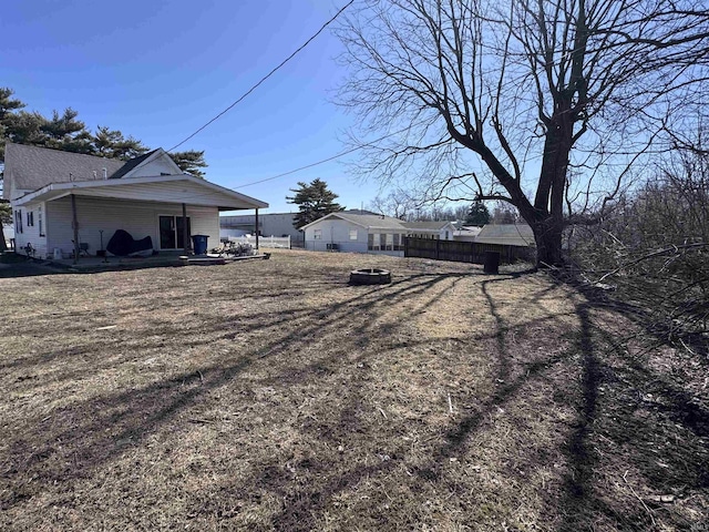 view of yard featuring a patio area, an outdoor fire pit, and fence