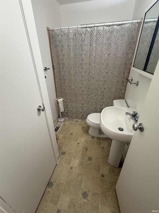 bathroom with curtained shower and toilet