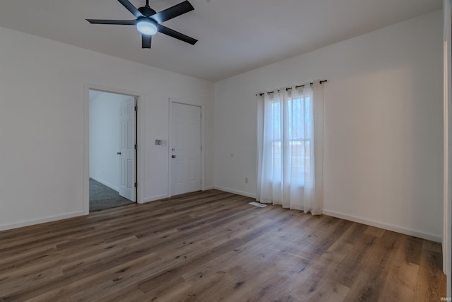 spare room with wood finished floors, baseboards, and ceiling fan