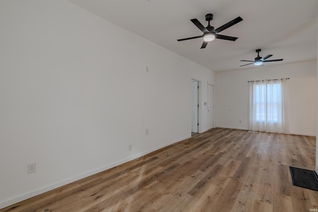 spare room with visible vents, baseboards, wood finished floors, and a ceiling fan