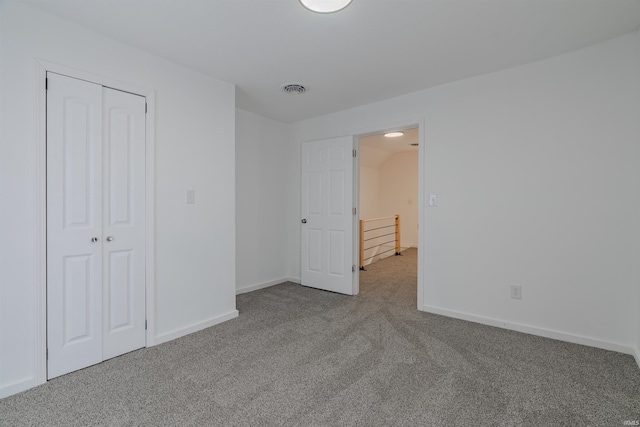 unfurnished bedroom with a closet, visible vents, baseboards, and carpet floors