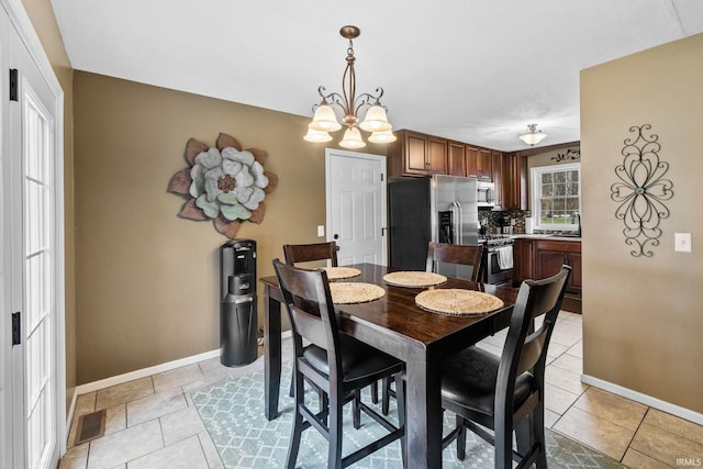 dining room featuring a chandelier, visible vents, baseboards, and light tile patterned floors