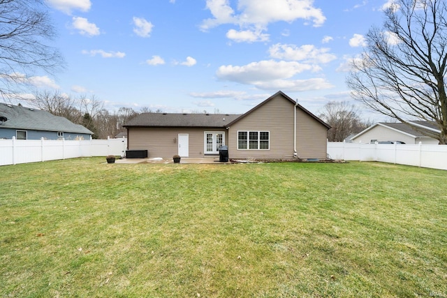 rear view of house with a patio area, a lawn, and a fenced backyard