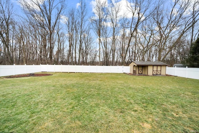 view of yard with an outbuilding, a storage unit, and a fenced backyard