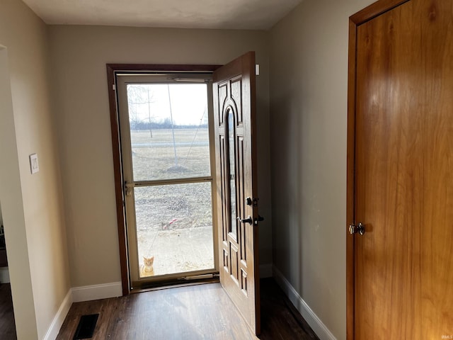 doorway to outside with visible vents, wood finished floors, and baseboards