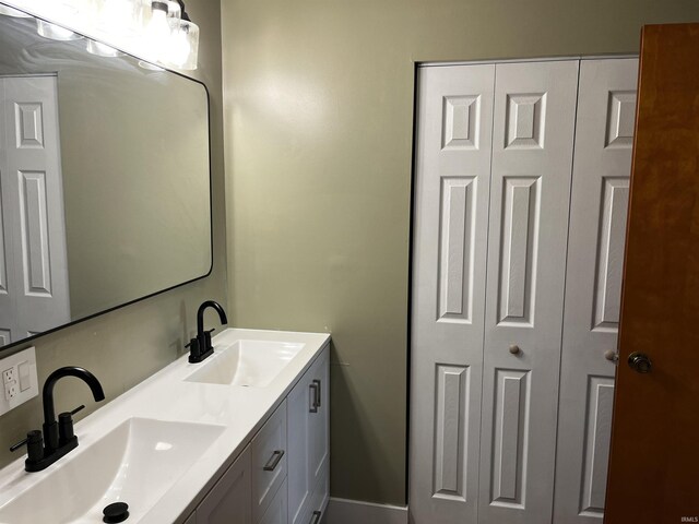 full bathroom featuring double vanity, a closet, and a sink