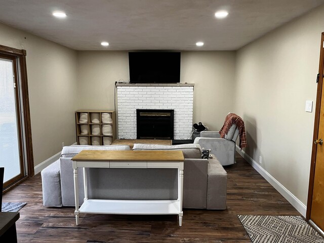 living area with a brick fireplace, recessed lighting, dark wood-style floors, and baseboards