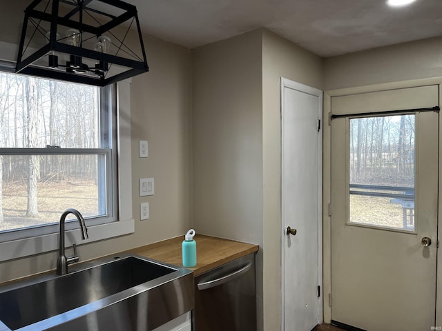 kitchen with a sink, dishwasher, and butcher block counters