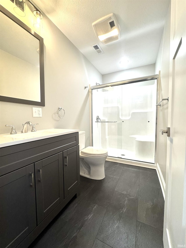 bathroom featuring visible vents, toilet, a textured ceiling, a shower stall, and vanity