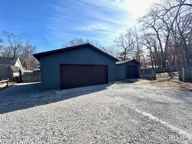 detached garage featuring fence