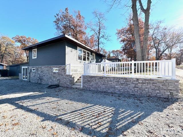 view of side of home with stone siding