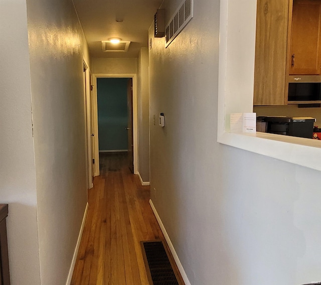 hallway featuring attic access, baseboards, and visible vents